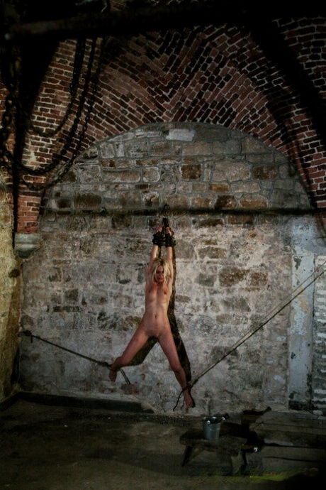 Naked blonde Mirela is whipped by captors while chained to cellar wall 45900710