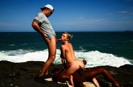 Busty blonde engages in hardcore MMF sex on a rocky shoreline 97827425