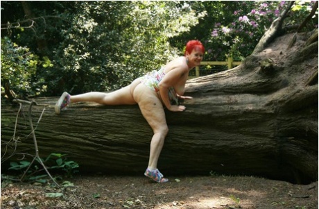 Older redhead Valgasmic Exposed gets totally naked in a public park 49586507