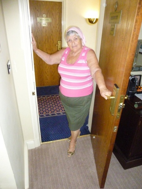 Obese grandmother licks her own nipples as she strips naked in living room 26992670