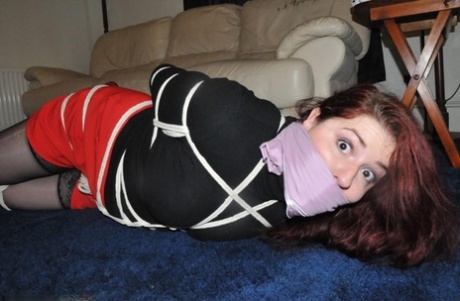 Helpless female struggles against her restraints while hogtied and silenced 77650241