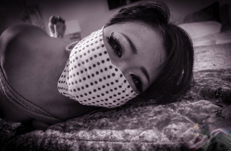 Asian chick is tied up with ropes on a bed before being blindfolded 22380584