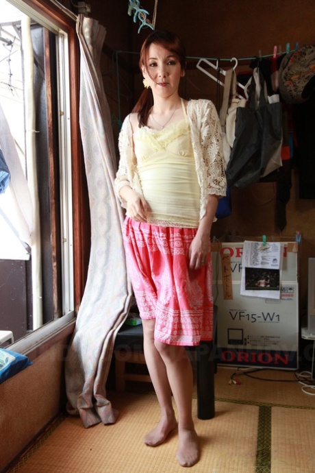 Japanese redhead Chika Sasaki strips to tan stockings in front of a window 88644576