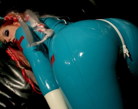 Solo model poses in a latex nurse uniform for a safe for work spread 99937311