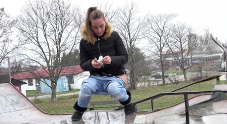 White girl Naomi Bennet pees in a puddle at a skate park during the day 17837343