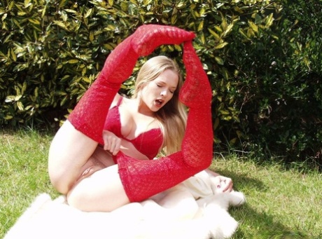 Blonde British beauty Tamara Noon pulls down red hose while in a yard 11632618