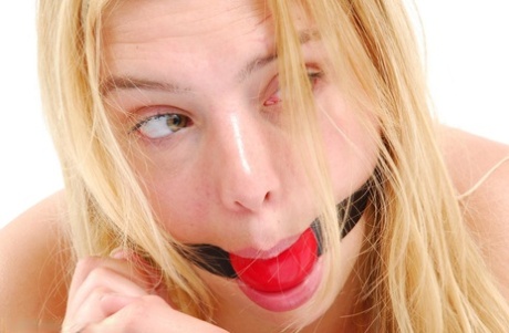 Blonde girl affixes a ball gag before donning stainless steel cuffs 64355926