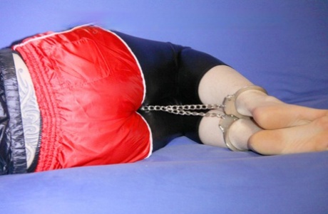 Hot brunette dons a gag while cuffed and chained in a nylon coat 93061299
