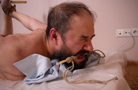 Dominant women hogtie a submissive man upon a mattress while fully clothed 38579659