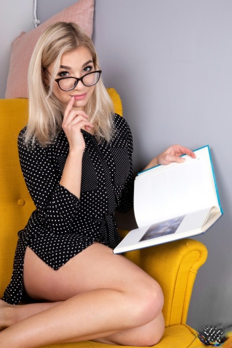 Geeky blonde Amelia undresses on a chair before playing with her shaved pussy 10402655