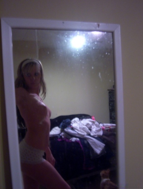 Blonde teen takes selfies while going topless in front of a mirror 40069897