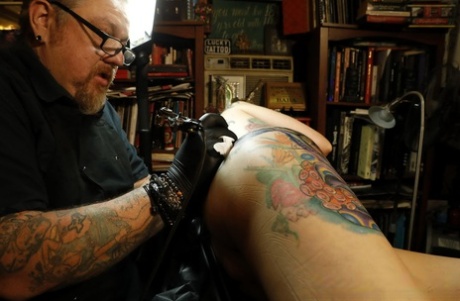 Tattoo enthusiast Marie Bossette grimaces while getting ink in a delicate spot 91353352