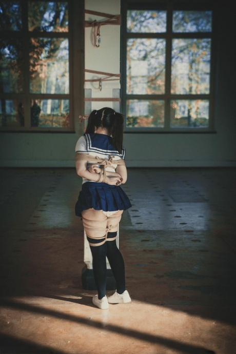 Japanese schoolgirl Carmineworx is tied up upside down against a post 30123189