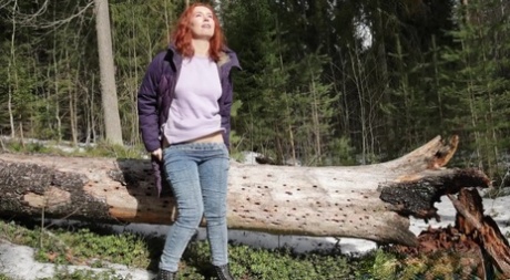 Natural redhead Nikky B takes a badly needed pee while out in the woods 32352645