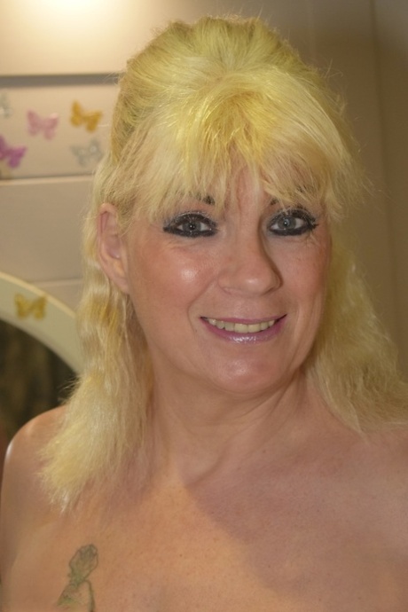 Naked older blonde Dimonty blow dries her hair before donning stockings 19746509