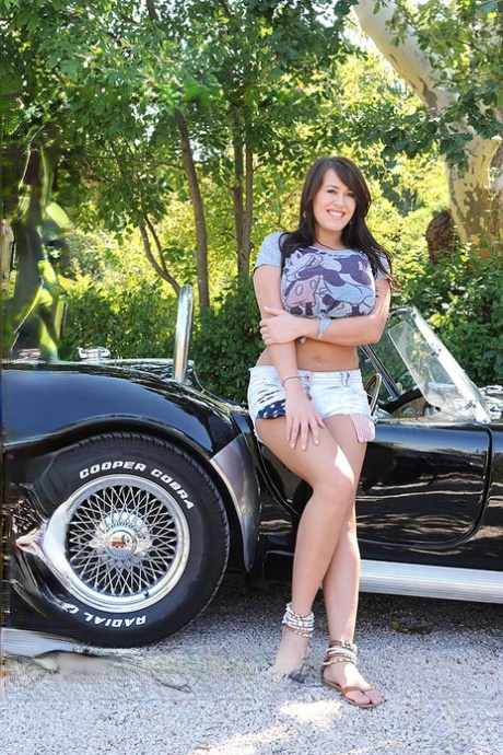 Busty babe in shorts Leanne Crow exposing her melons near a roadster 25015131