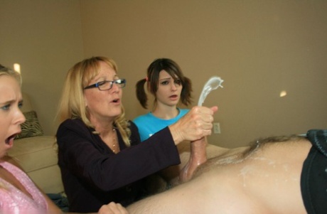 Mature blonde in glasses teaching her teen friends how to stroke a big cock 89511449